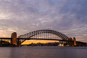 Fototapeta na wymiar Cloudy dusk view over Sydney Harbour Bridge.