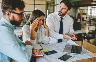 Caucasian boss dissatisfied with project employees feeling stress and headache from deadline in office, male and female partners solving problems disappointed with together working process indoors