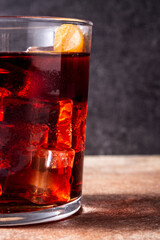 Boulevardier cocktail and orange zest on rusty background.Copy space