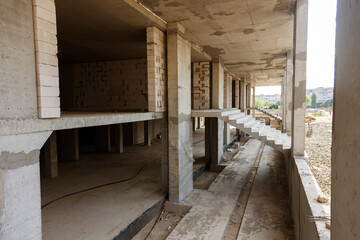 construction cranes on industrial construction site with silhouetted over amazing abstract sunrise sky and dramatic cloud background in the evening