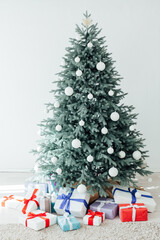 The interior of the white room with a blue Christmas tree with gifts for the new year decor winter postcard