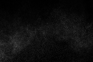 Abstract splashes of water on black background. Freeze motion of white particles. Rain, snow overlay texture.