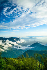 Under the blue sky at High Altitude, the huge mountains of the Himalayas are covered by clouds