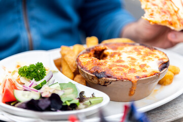 Food on the English Pub such as portion of lasagne, chips and salad