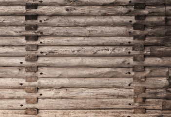 Old brown wooden wall made of rough logs. Texture