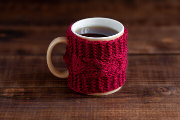 Cup of hot black tea on wooden table, close-up