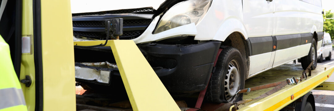 Wrecked car stands on tow truck closeup. Car evacuation services concept