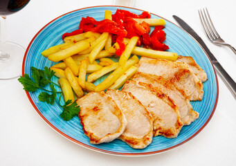Close up of tasty fried pork with french fries, served on plate