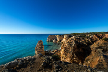 View of the scenic Marinha Beach (Praia da Marinha) from the top of the cliffs, in the Algarve region, Portugal; Concept for travel in Portugal and summer vacations.