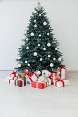 The interior of the white room with a blue Christmas tree with red gifts for the new year decor winter postcard