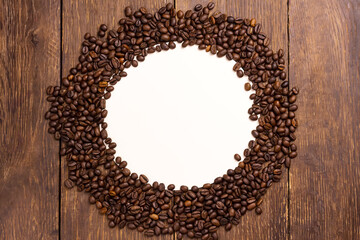 Coffee beans wit white round on wood background