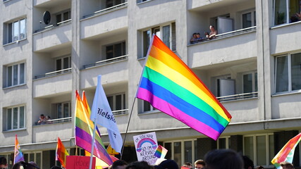 LGBT equality march or pride parade. Young people wearing rainbow clothes and symbols are fighting for LGBTQ+ rights. Rainbow flags, banners.