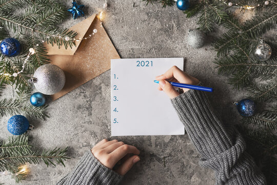 Cup of hot cocoa or chocolate with marshmallow, holiday decorations and notebook with to do list on turquoise vintage table from above, christmas planning concept. Flat lay style.