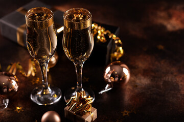 Christmas champagne, gas bubbles, confetti and blurry lights on a dark background