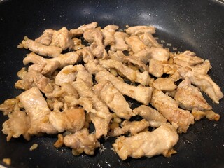 Fried pieces meat close-up, cooked pork from fat meat at home. Food cooked in frying pan. Delicious frying of meat products.