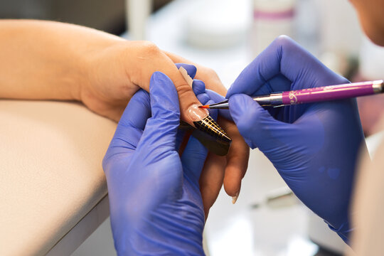 Nail extension with gel Treatment hand and nail care, the woman to a beautician for a manicure.