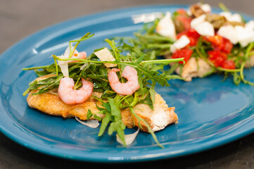 Bruschetta with shrimp, arugula, tomatoes, cheese and sauce, close-up, high Italian cuisine