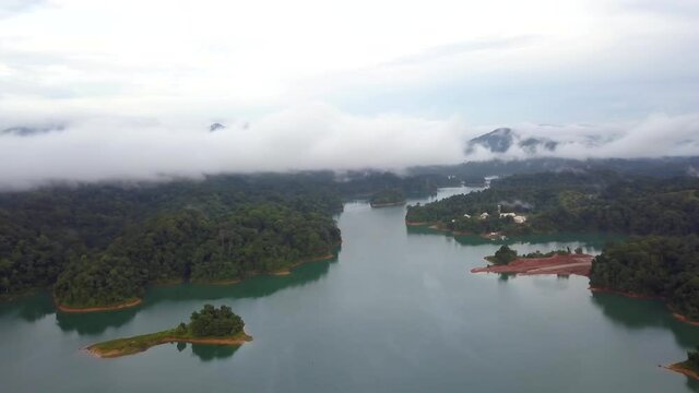 Aerial rotating view of morning fog in Kenyir Lake, Malaysia.