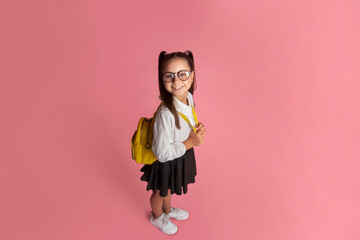 Funny child, early education and school life. Happy girl in uniform with backpack