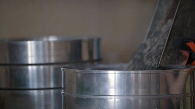 Slowmo: Laboratory Technician Pours Asphalt Samples in to Silver Strainer Barrel