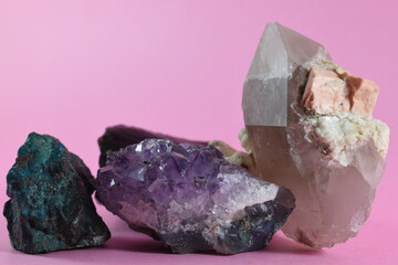 minerals and rocks placed on a pink background
