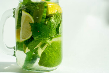 Health care, fitness, healthy nutrition diet concept. Fresh cool lemon cucumber mint infused water, cocktail, detox drink, lemonade in a glass jar.