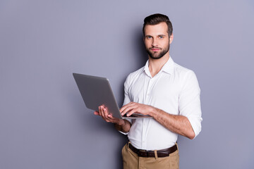 Portrait of his he nice attractive focused skilled brunet guy employer using laptop researching analyzing web market browsing finance report isolated over gray pastel color background