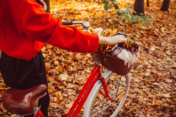 Portrait of a pretty girl with a red bike in the autumn forest