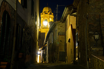 Obraz premium Italy Tuscany Castiglione della Pescaia, pink full moon view of the alleys with night light, the bell tower of the ancient church