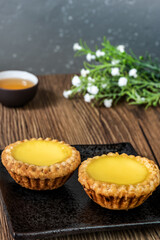 Two Delicious freshly baked egg tarts served with Chinese tea