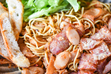 Close up stir fried spicy spaghetti with sausage ham vegetables and cheese on plate /