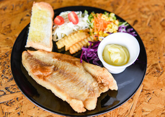 fried fish fillet - Fish dish steak fish with sauce cream french fries bread and fresh vegetables on plate