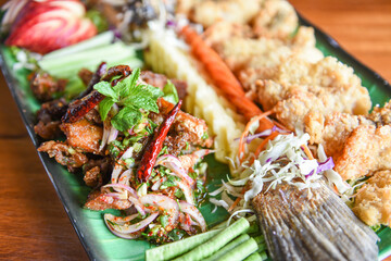 sea bass fish fillet cooked food Thai style Asian - Salad seabass fried fish crispy decorated on plate served on wooden table food dinner