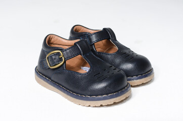 cute little vintage retro blue leather baby dolly shoes, isolated on a white studio background.  Tiny baby sneakers for a baby shower. Babies feet grow fast.