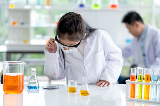 Lovely little girl enjoy to examine the color chemical in laboratory with day light. Concept of good practice and education of science for children support their learning.