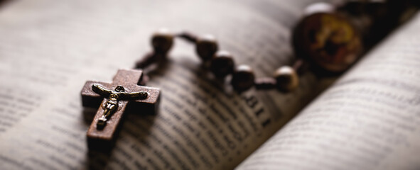 Christian wooden crucifix on open bible, point focus. Religious concept image - obrazy, fototapety, plakaty