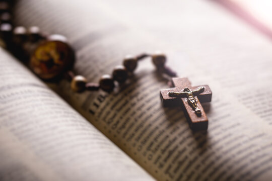 Christian wooden crucifix on open bible, point focus. Religious concept image