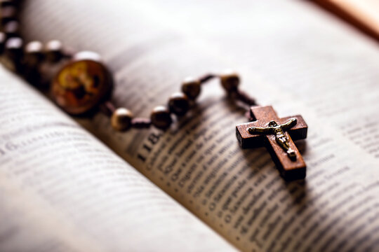 Christian wooden crucifix on open bible, point focus. Religious concept image