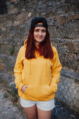 City portrait of handsome beautiful plus size girl wearing casual yellow blank hoodie or sweatshirt with space for your logo or design. Mockup for print