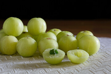 Indian Gooseberry fruit on white table cloth and wooden table