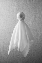 Fototapeta na wymiar Flying Halloween Ghost. Scary white ghost on light gray background. Vertical orientation