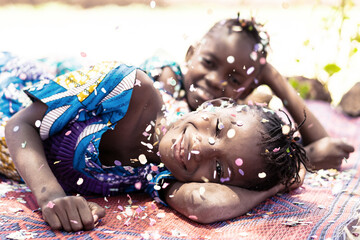 Birthday Party and Holiday Concept by Celebrating happiness, young African girls with big smiles and confetti