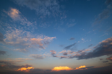 Obraz premium Summer sunset sky with fleece colorful clouds. Evening dusk good weather natural background.