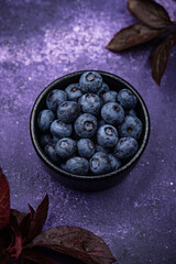 Fresh ripe blueberry on purple background