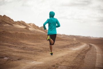Fitness woman trail runner cross country running  on sand desert