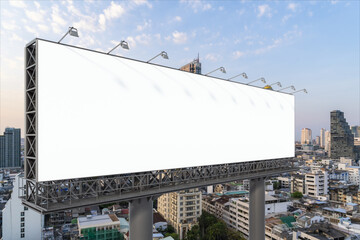 Blank white road billboard with Bangkok cityscape background at sunset. Street advertising poster, mock up, 3D rendering. Side view. The concept of marketing communication to promote or sell idea.