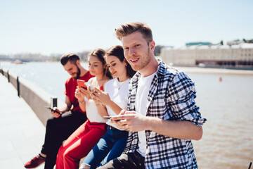 Portrait of handsome man enjoying gather meeting with Caucasian hipster guys playing online games...