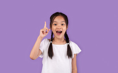 Little Asian Girl Pointing Finger Up Having Idea, Purple Background