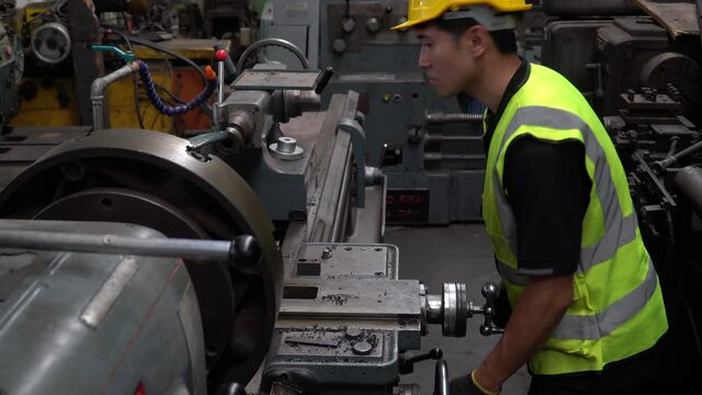 Factory Engineer control lathe machine in the industrial plant