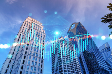 Fototapeta na wymiar FOREX and stock market chart hologram on low, wide angle view of glass and steel contemporary skyscrapers in financial downtown. The concept of international trading. Double exposure.